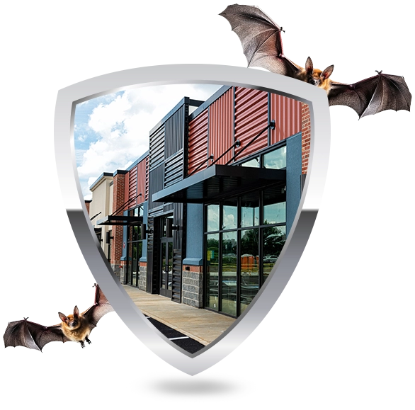 Wildlife commercial bat removal services – shield logo with modern building protected from bats, representing safe and humane exclusion solutions.