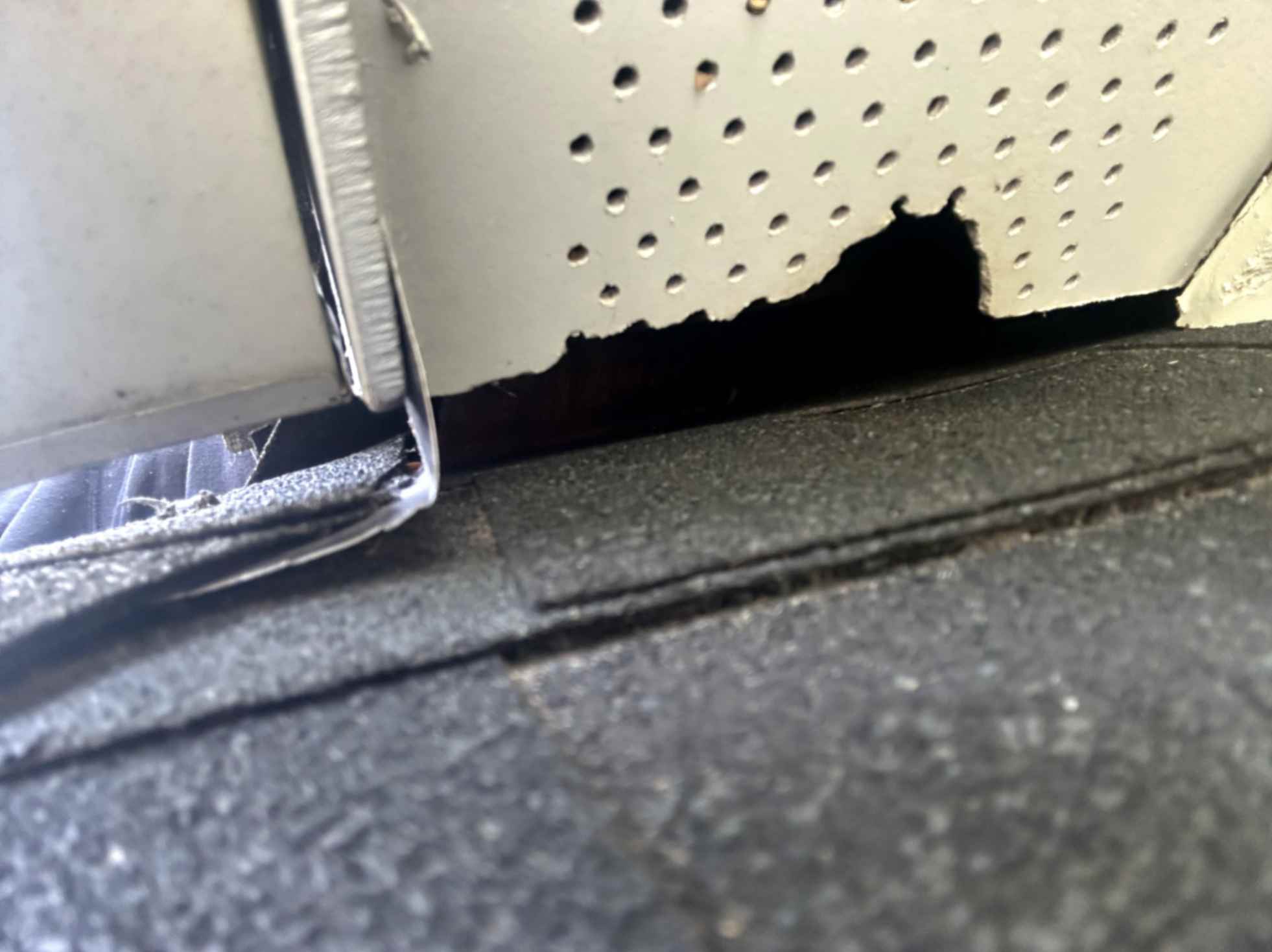 The image shows a gap or hole in a roof or ceiling, with some material peeling away. It appears to be an area of damage or potential entry point for animals like squirrels, taken during Squirrel Removal in Davidson.